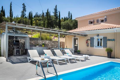 une terrasse avec des chaises blanches et une piscine dans l'établissement Villa Andromahi, à Fiskardho