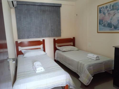 two beds sitting next to each other in a room at Apto. 100m da feirinha da beira mar in Fortaleza
