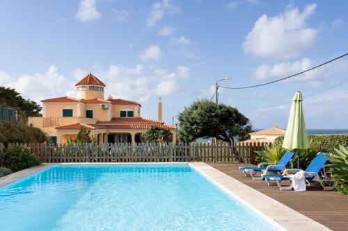 une villa avec une piscine en face d'une maison dans l'établissement JOIVY Splendid 4-BR House with Swimming Pool and Sea View, à Colares