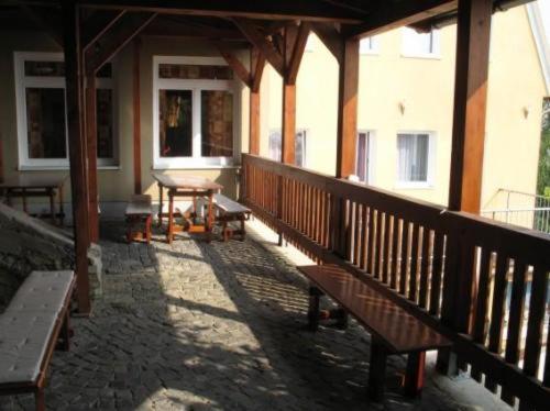 a porch with benches and a table on a building at Pension Zlata Noha in Bratislava