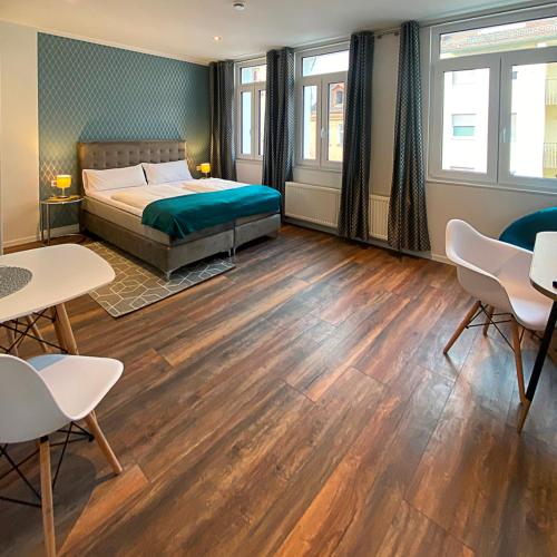 a bedroom with a bed and tables and chairs at Nurban Apartments Oldtown in Nürnberg
