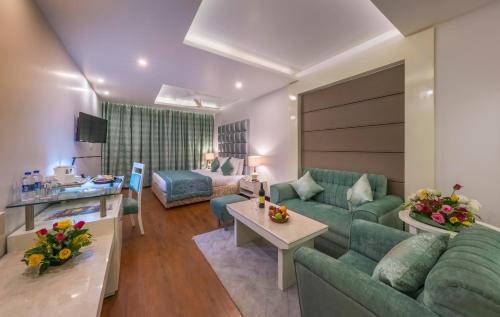 a living room with a couch and a table at Hotel Hindusthan International, Bhubaneswar in Bhubaneshwar