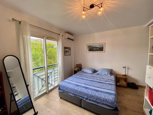 a bedroom with a bed and a large window at Au bord du Lagon ! in La Saline les Bains