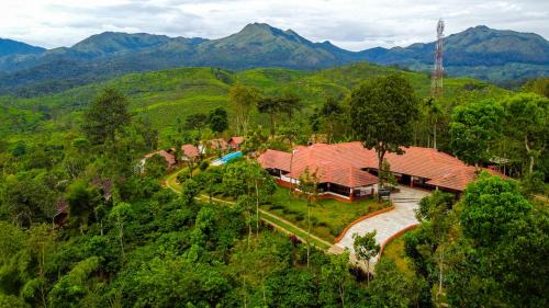 an aerial view of a house with mountains in the background at Pranavam Resort & Spa in Tariyod