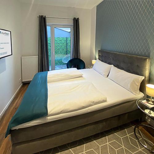 a large bed in a room with a window at Nurban Apartments Oldtown in Nürnberg