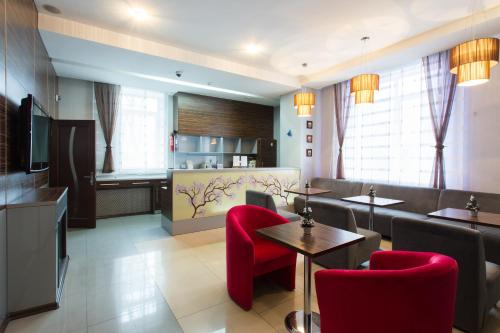 a restaurant with red chairs and tables and a kitchen at Hotel Voyage in Kharkiv
