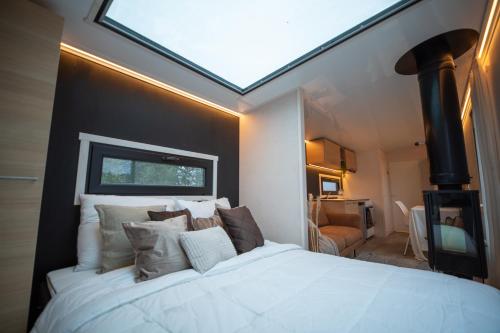 1 dormitorio con 1 cama blanca grande y tragaluz en Mansikkaharju Holiday Camp en Leppävirta