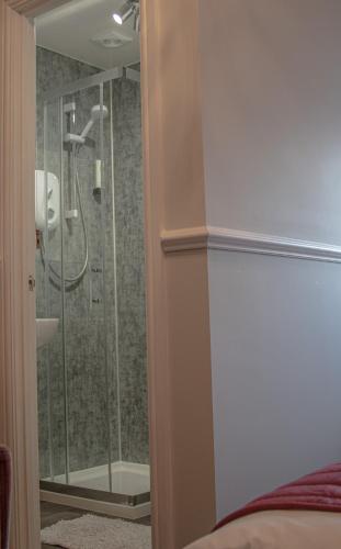a bathroom with a shower with a glass door at Abbey Court Guest House in Carlisle