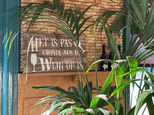 a sign on a brick wall next to a plant at Hotel Munten in Weert