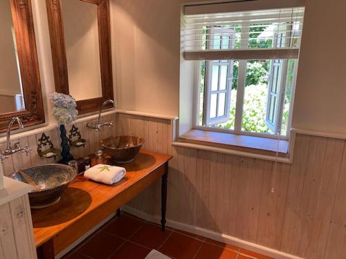 a bathroom with two sinks and a window at Bredon Cottage in Hogsback