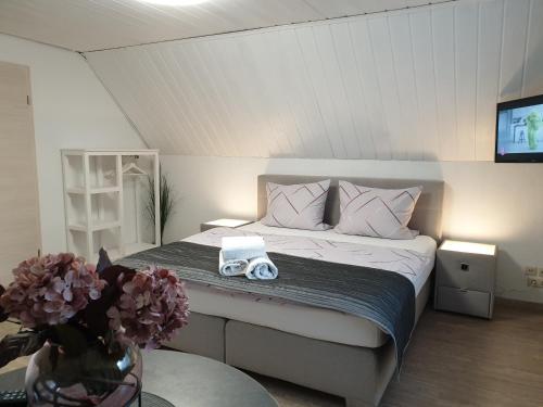 a bedroom with a bed with a tv and flowers at Scholz & Scholz GbR Zimmervermietung in Hoyerswerda