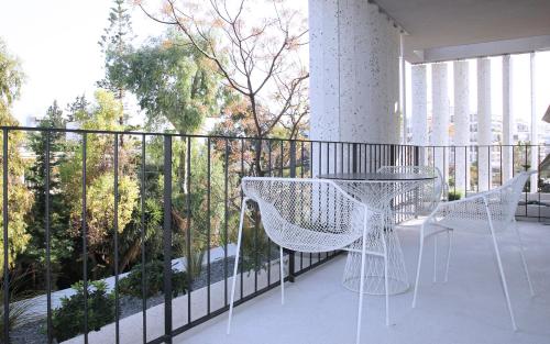 a balcony with two chairs and a table on it at Ogarden in Athens