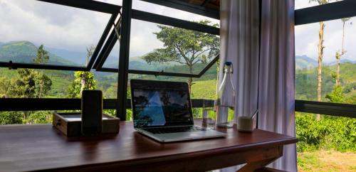 a laptop computer sitting on a desk in front of a window at Pranavam Resort & Spa in Tariyod