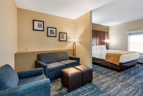 a hotel room with a bed and a couch and chair at Comfort Suites West Memphis I-40 I-55 in West Memphis