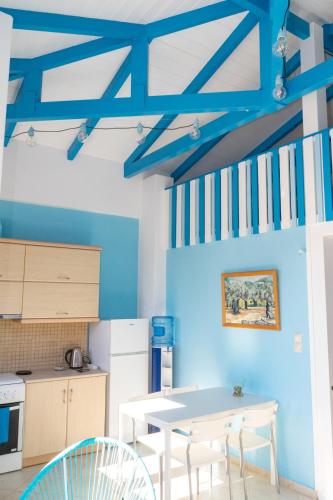 a kitchen with blue walls and a table and chairs at Iris Villas in Spárton
