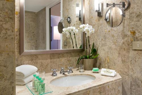 a bathroom with a sink and a mirror at Warwick Grand-Place Brussels in Brussels