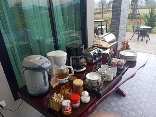a table with a coffee maker and cups on it at Baan chomphu @Pua in Pua