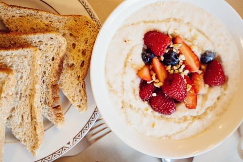 a bowl of yogurt with fruit and berries and toast at Ross Beach Family Farmhouse B&B in Killala