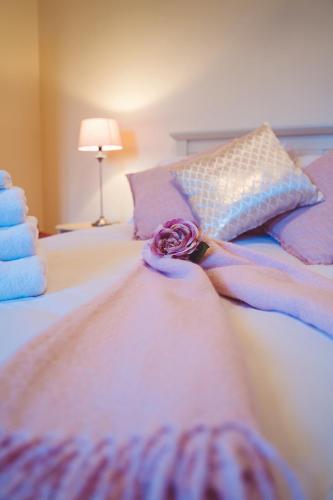 a bed with a rose on top of it at Ross Beach Family Farmhouse B&B in Killala