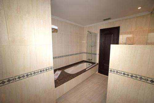 a bathroom with a bath tub, toilet and sink at Motel Caribe in Vigo