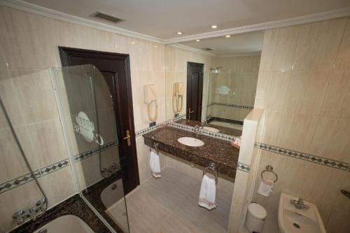 a bathroom with a toilet, sink, and mirror at Motel Caribe in Vigo