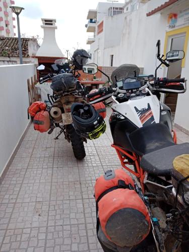 two motorcycles parked next to each other on a street at Casa Da Praia "AL" in Monte Gordo