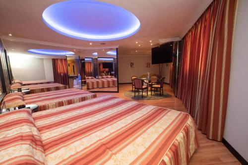 a hotel room with two beds and a television at Motel Caribe in Vigo