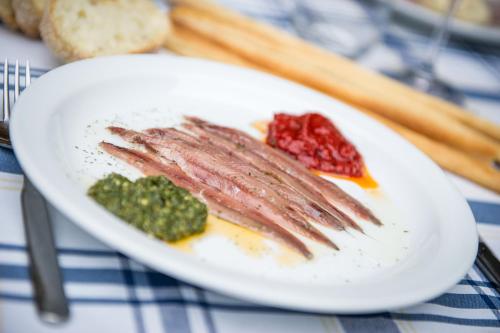 a plate of food with meat and fruit on a table at Locanda Occitana Cà Bianca in Roccabruna