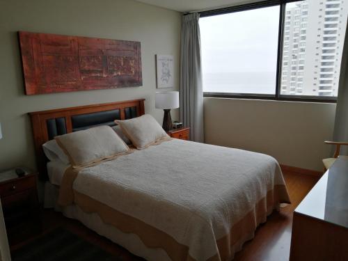 1 dormitorio con cama y ventana grande en Temporary Rent Viña del Mar, en Viña del Mar