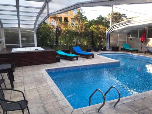 een groot zwembad met stoelen en een tafel bij Rey del Bosque Apart - Hotel & Spa in Valeria del Mar