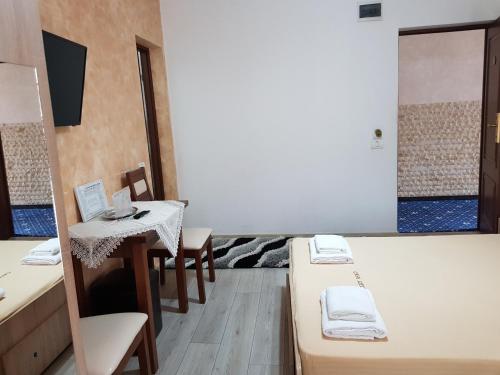 a room with beds and a table and chairs at Casa Lipianu in Târgu Jiu