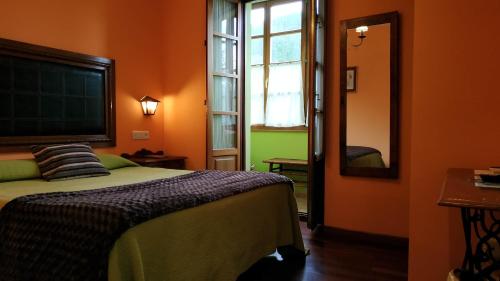 1 dormitorio con cama y espejo grande en Hotel Casa Vieja del Sastre, en Soto de Luiña