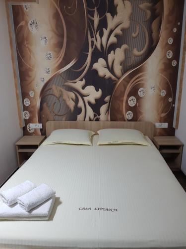 a bed with two towels sitting on top of it at Casa Lipianu in Târgu Jiu
