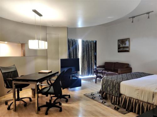 a hotel room with a bed and a desk and a table at Hotel Satkar Residency in Thane