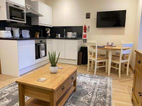 a living room with a kitchen and a table at Waverley Inn Holiday Apartments in Inverness