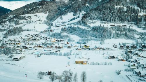 a village covered in snow on a mountain at Hotel Sportalm - Adults Only Boutique Hotel in Bad Kleinkirchheim
