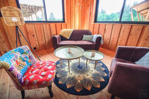 a living room with two chairs and a table at Domaine de la Vitarelle Glamping in Villanière