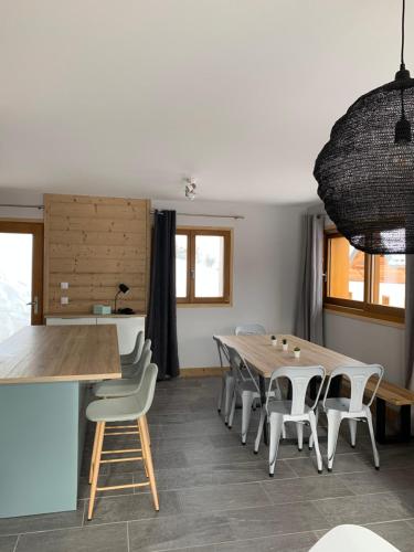 une salle à manger avec une table et des chaises en bois dans l'établissement La suite du skilodge, à La Toussuire