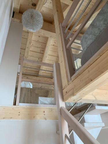 une chambre mansardée avec des plafonds en bois et un lustre dans l'établissement La suite du skilodge, à La Toussuire