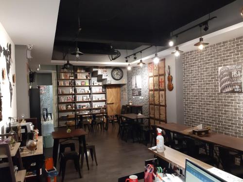 Un restaurante con mesas y sillas y una pared de ladrillos. en Quiet Hostel - Minquan Inn, en Tainan