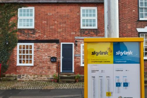 a sign in front of a brick house at Gateway Mews - Serviced Apartments in Kegworth
