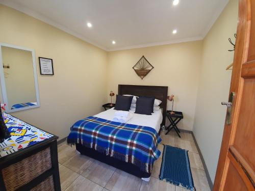 a small bedroom with a bed and a mirror at Lebo's Soweto Backpackers in Soweto