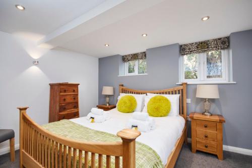 a bedroom with a wooden bed and two windows at The Hidden Gem in Kegworth