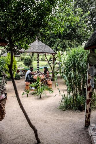 two people sitting at a table under an umbrella at Lebo's Soweto Backpackers in Soweto