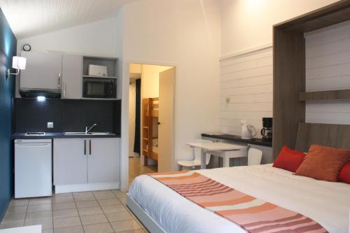 um quarto com uma cama e uma cozinha com um lavatório em Résidence du Parc Hossegor em Hossegor