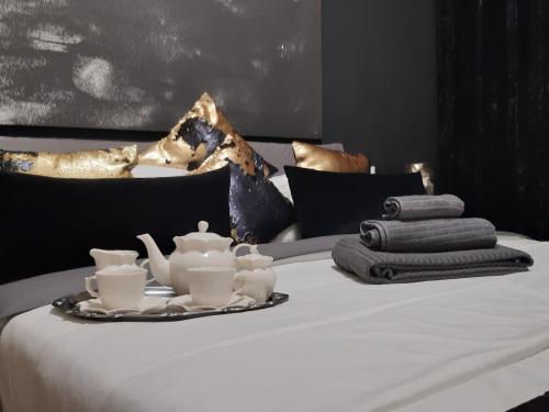 ein weißes Bett mit einem Tablett mit Teezubehör darauf in der Unterkunft La petite maison in Padua