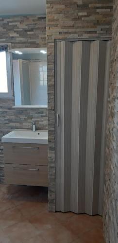 a bathroom with a shower with a sink and a mirror at Porteo - Les Terrasses du Port in Centuri