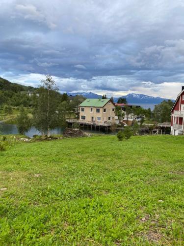 ein Grasfeld mit Häusern und einem See in der Unterkunft House on the lake in Bogen