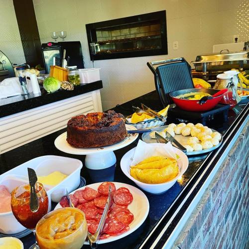 een buffet met veel gerechten op een aanrecht bij RANCHO COSTEIRO AGROTURSIMO E BALNEARIO E PESQUEIRO in Pôrto Xavier