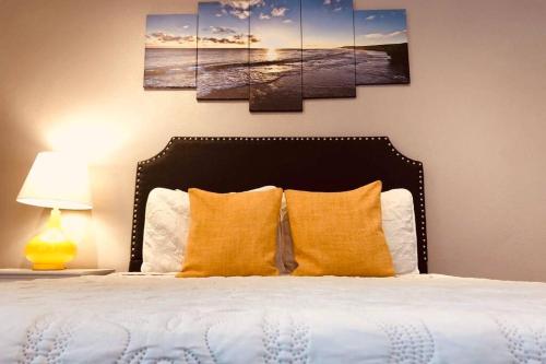 ein Schlafzimmer mit einem Bett mit vier Gemälden an der Wand in der Unterkunft King & Queen Suite #7 in Nassau